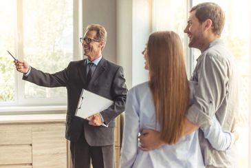 A man giving a couple a tour of a real estate property