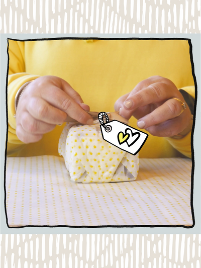 Hands wrapping a gift.