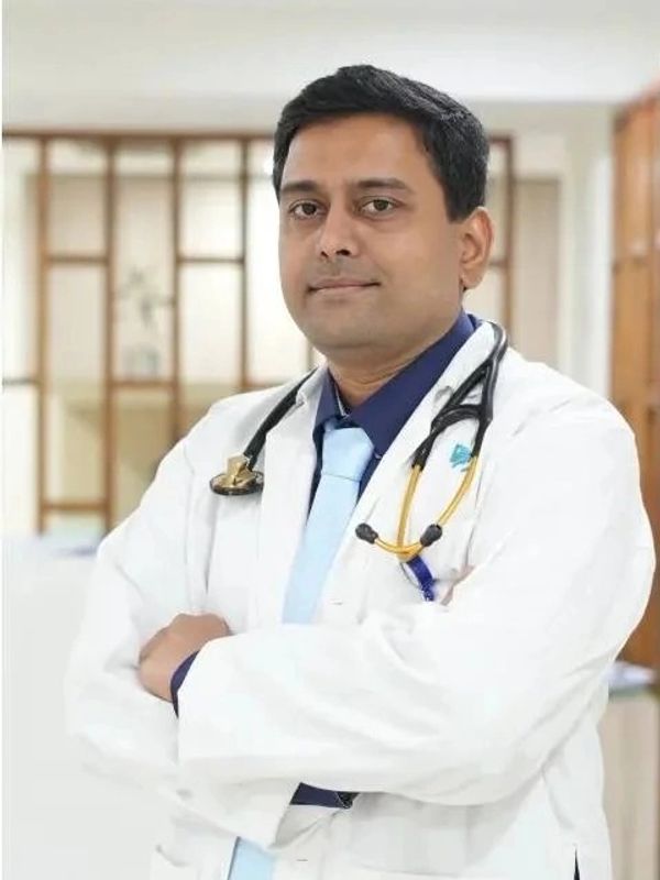 Confident male doctor with stethoscope in a clinical setting.