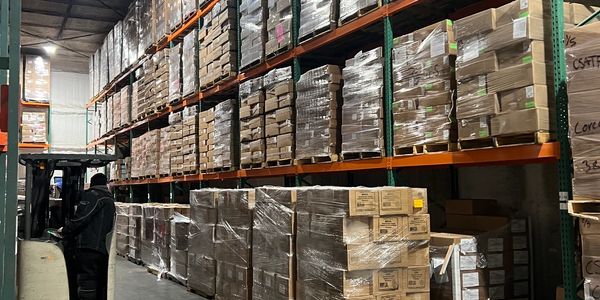 Warehouse shelves stocked with boxed goods.