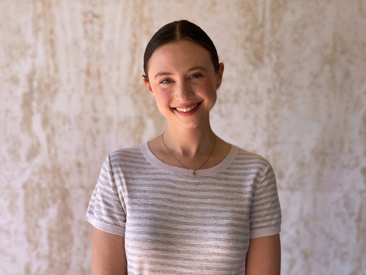 Young woman smiling in a striped shirt.