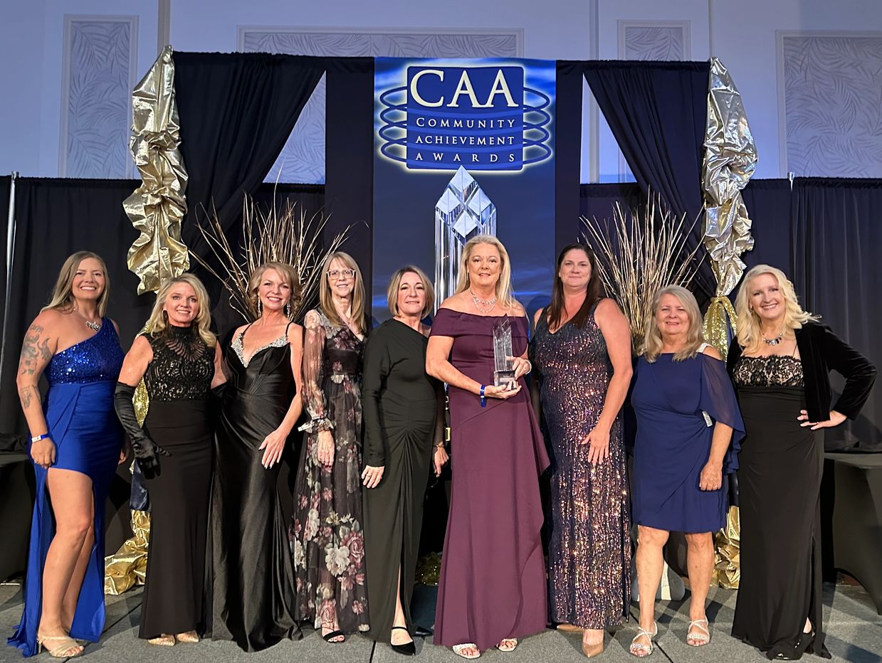 Group of women smiling and holding award