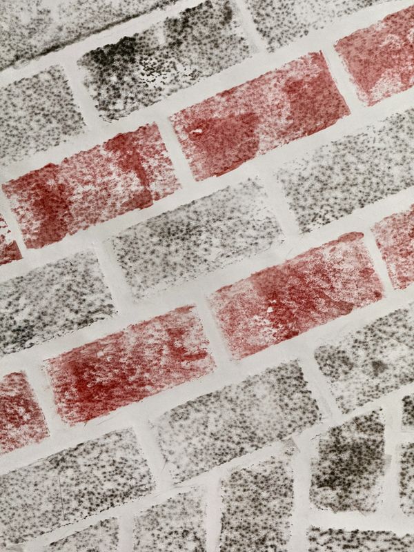 Close-up of a textured brick wall with red and gray bricks.