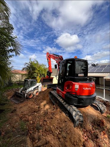 Excavator and skid steer loader working on dirt.