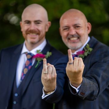 Same sex wedding. Two grooms proudly display their new wedding rings. LGBT+ wedding in Bristol.