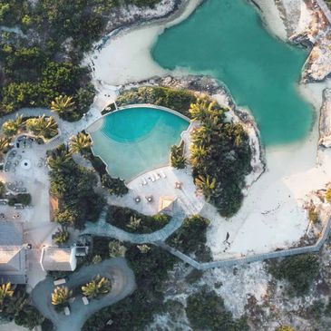 Aerial view of a tropical resort with a pool and lagoon.