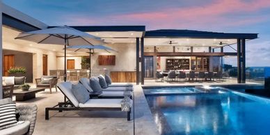 Modern outdoor patio with pool and lounge chairs at sunset.