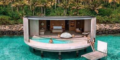 Luxury overwater villa with pool in turquoise ocean waters.