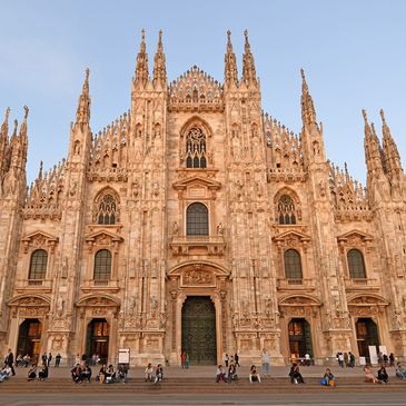 The ornate facade of Milan Cathedral under a clear sky.