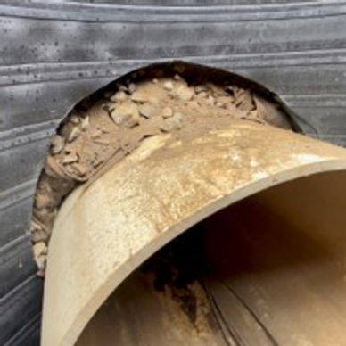 Leaking manhole pipe with soil intrusion and groundwater infiltration needing foam injection repair.