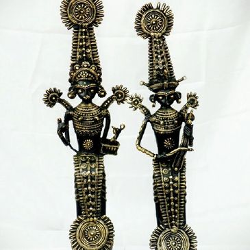 Two intricate tribal brass figurines with elaborate designs and tall headdresses.