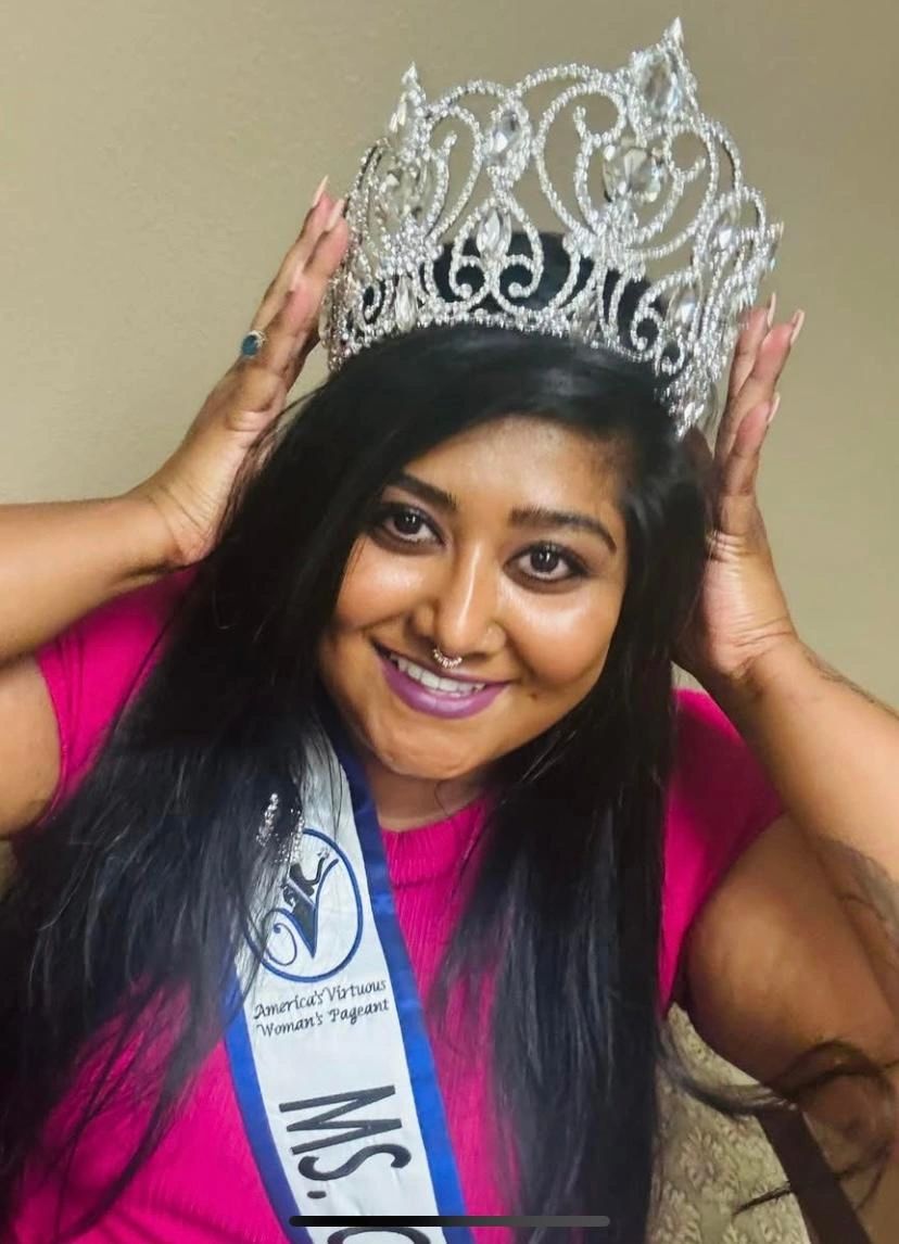 Smiling woman wearing a crown and sash from a pageant.