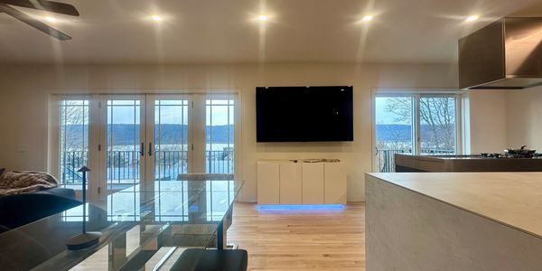 Modern living room with glass dining table and mountain view.