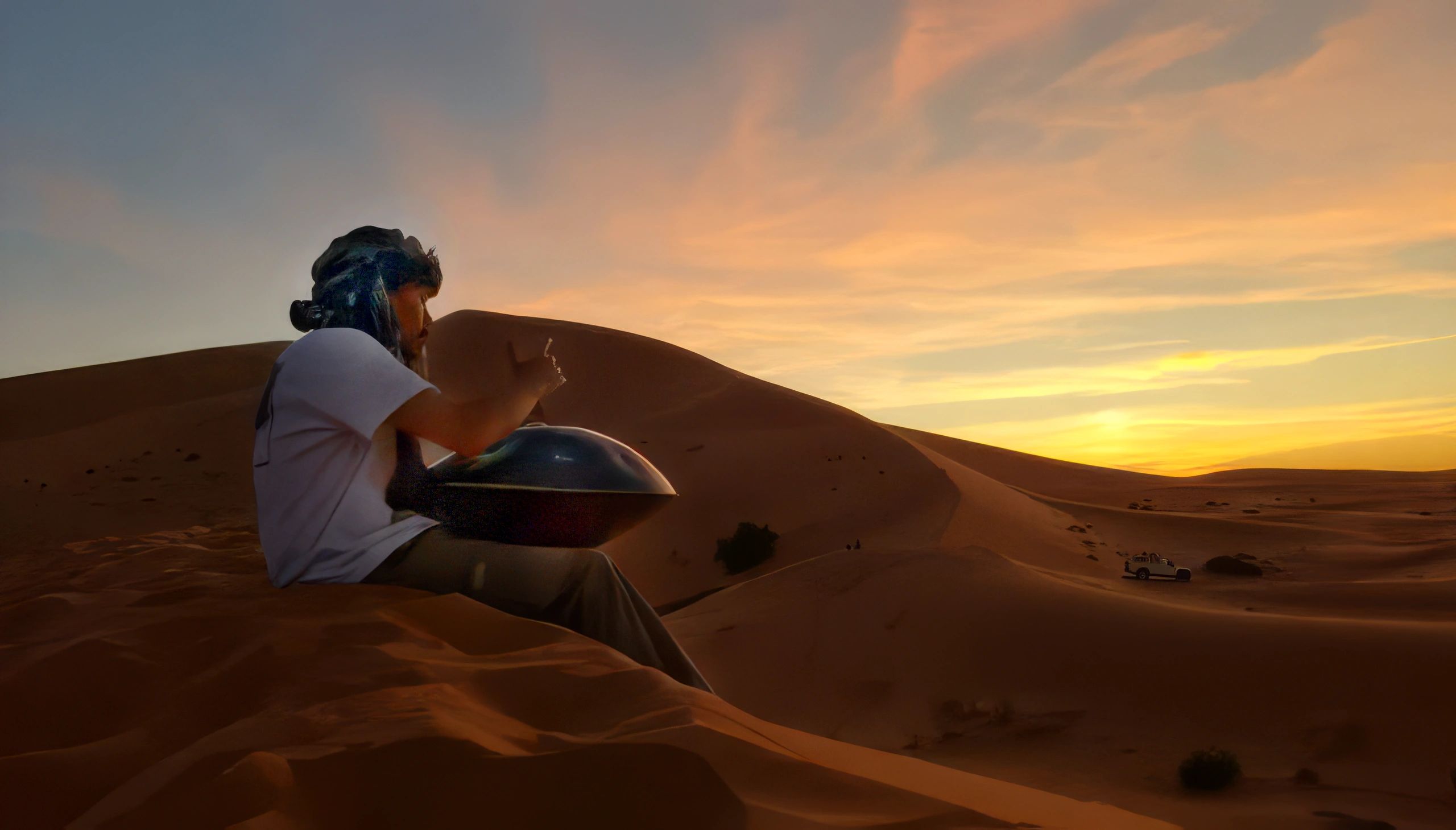 Danny Sorensen -HandpanLife, playing a Handpan at sunset on top of a sand dune in the Sahara Desert 