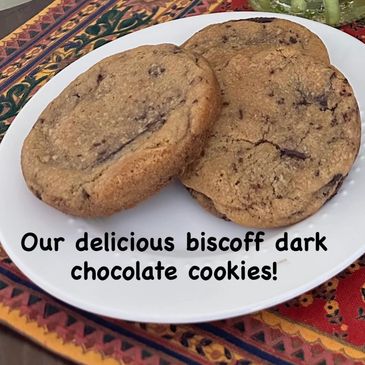 Three biscoff dark chocolate cookies on a white plate.