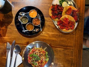 A spread of Indian dishes including tandoori chicken, naan, and chutneys.