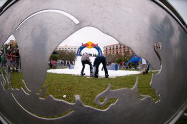 Snowboarding event viewed through a Red Bull logo cutout.