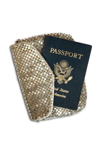 A U.S. passport resting on a gold sequined pouch.