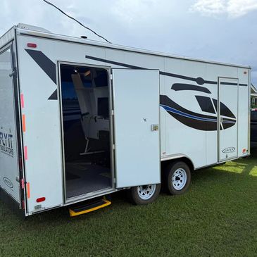 White trailer with a helicopter graphic and open side door showing interior.
