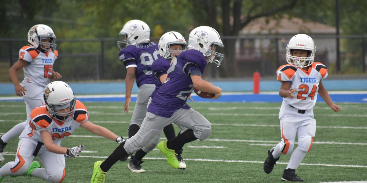 Youth football players in action on the field.