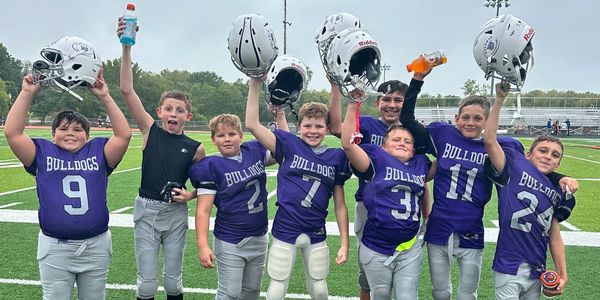 Youth football team celebrating on the field.