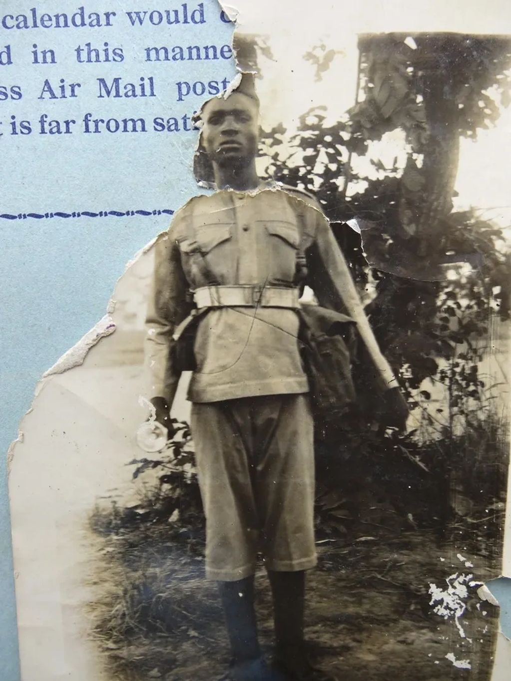 Torn vintage photo of a soldier in uniform.
