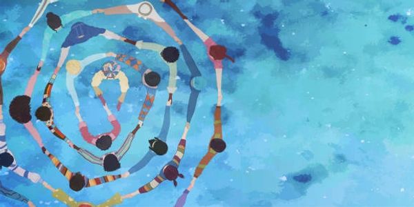 People holding hands in a spiral formation over blue water.