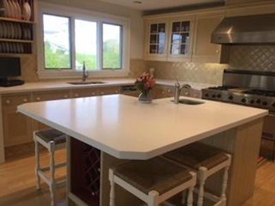 Seamless large kitchen solid surface island corian top.