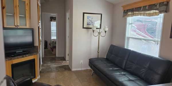 Cozy living room with black leather sofa and TV corner.