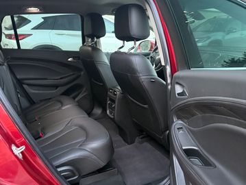 Interior of a red car showing back seats and door panel.