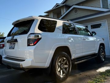 White SUV parked in driveway beside house.