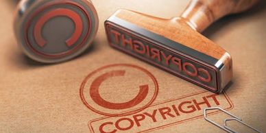A wooden rubber stamp imprinting 'COPYRIGHT' text.