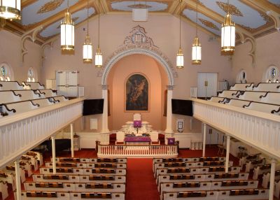 Interior view of a church sanctuary with pews and altar.
