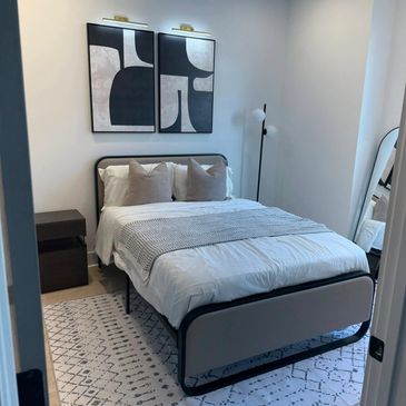 Modern bedroom with minimalist design, neutral tones, and abstract wall art.