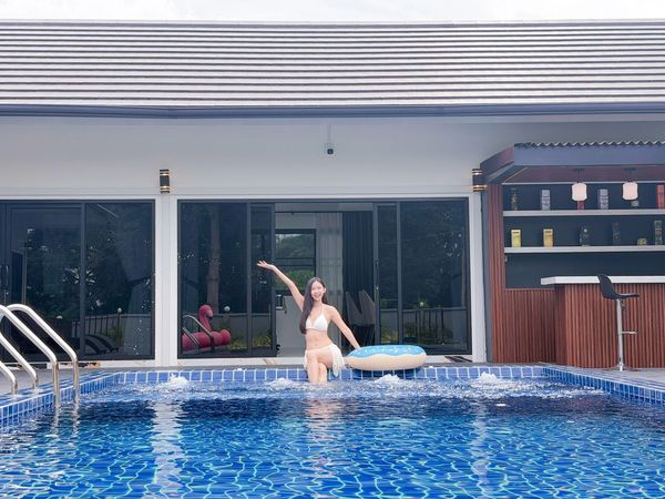 ผู้หญิงในชุดว่ายน้ำยืนในสระว่ายน้ำพร้อมแห่วงยาง