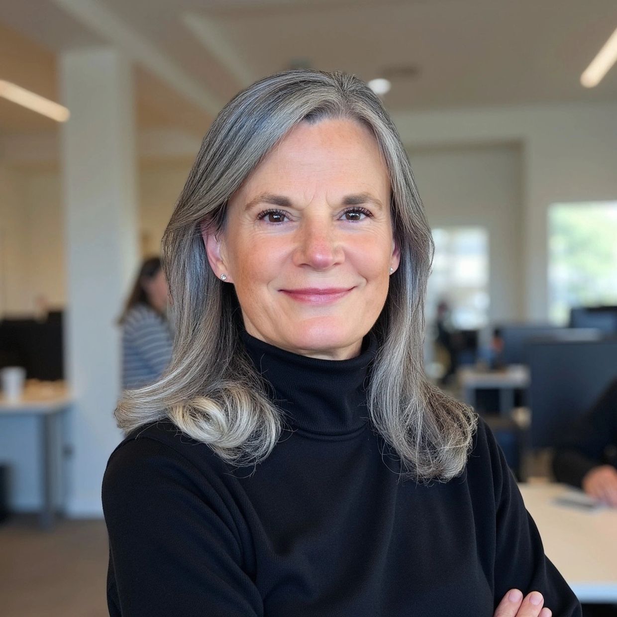 Confident middle-aged woman with gray hair in a black turtleneck.