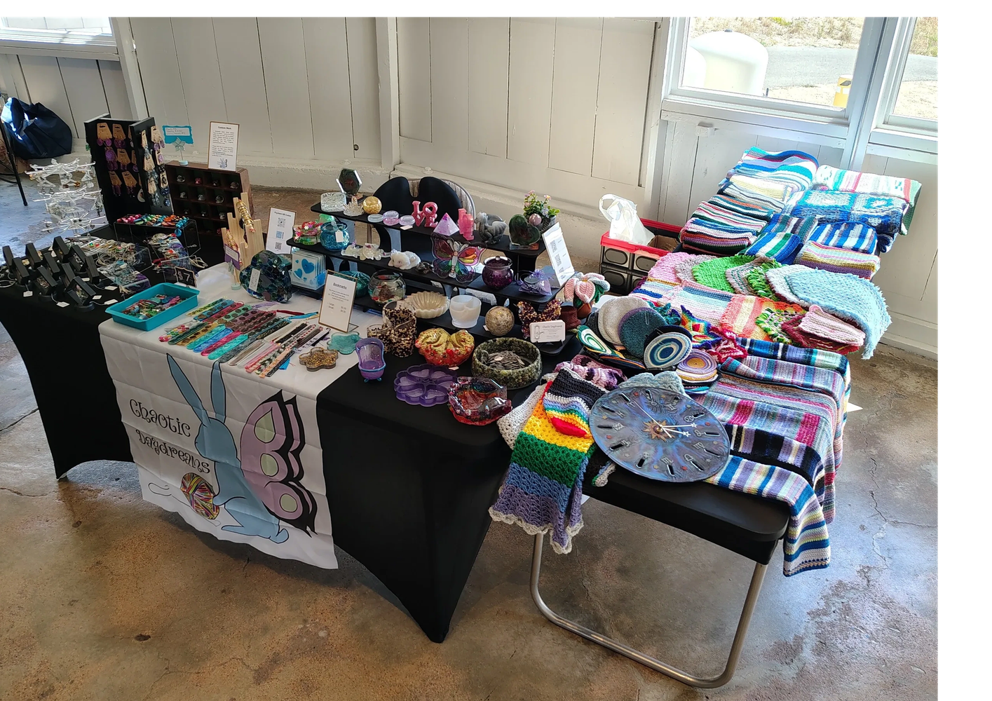 Handmade crafts and knitted items on display at a market booth.