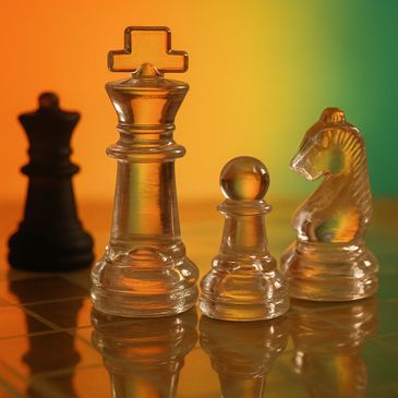 Transparent glass chess pieces on a colorful gradient background.