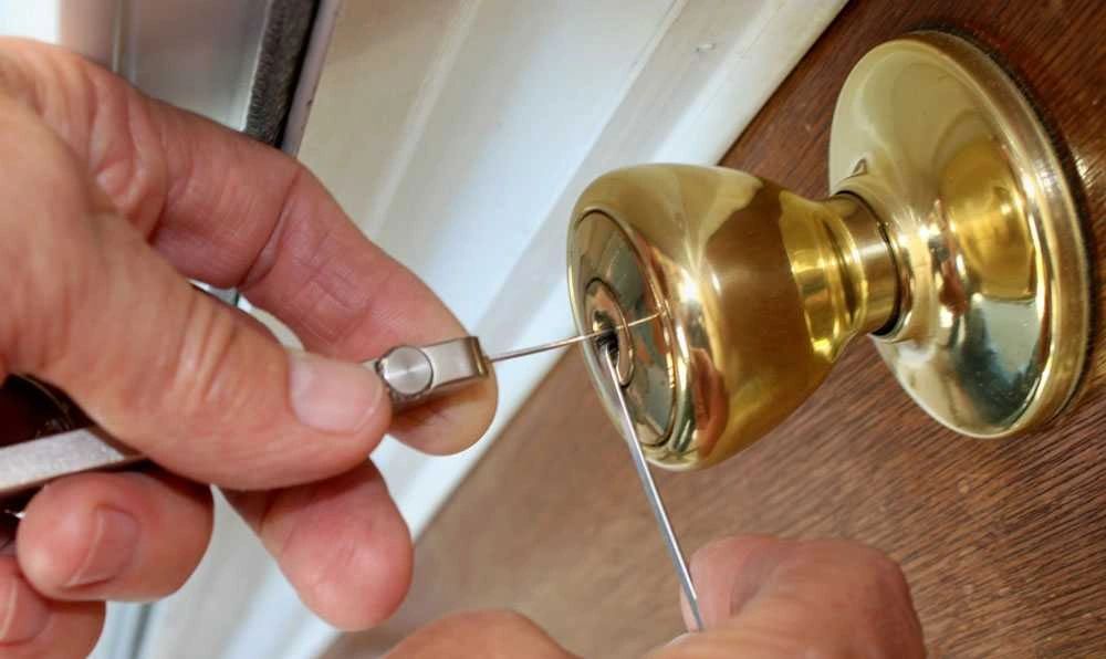 emergency home lockout using lock picking tools on a brass door knob.