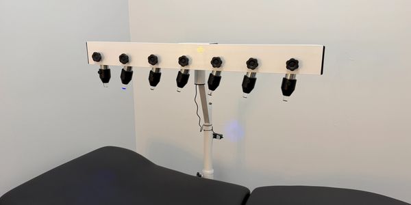 A medical examination table with attached diagnostic lights in a clinical setting.