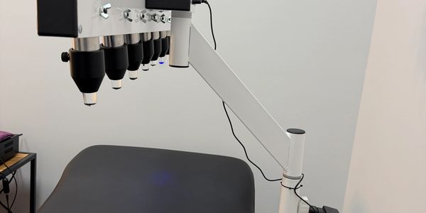 Medical device with multiple lenses above a treatment bed.