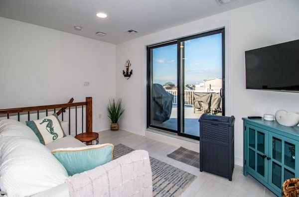 Cozy living room with coastal decor and sliding glass doors to a balcony.