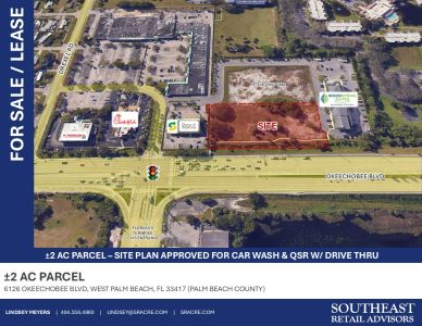 Aerial view of a 2-acre commercial parcel for sale with nearby businesses and traffic signals.