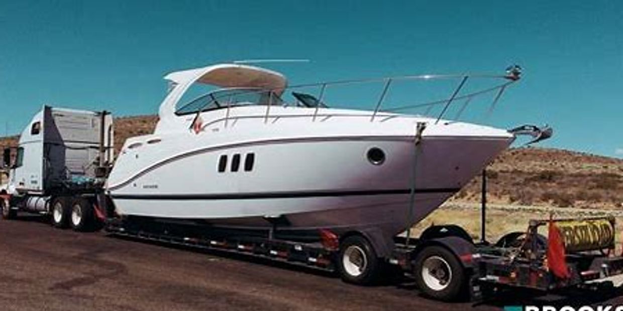 Large cabin cruiser being transported by semi.
