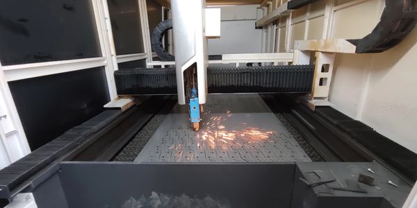 A laser cutting machine sparks while cutting metal sheet.