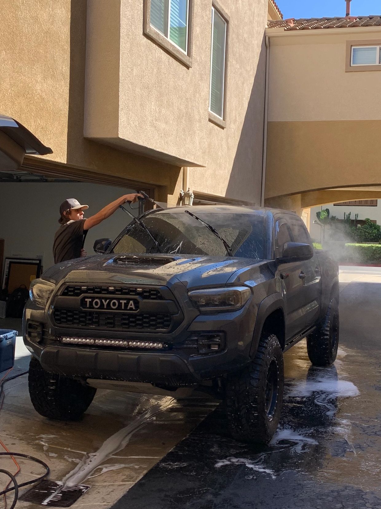 In this photo one of our detailers Parker is rinsing heavy dirt off a truck in order to prep the sur
