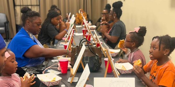 Group painting and eating pizza together.