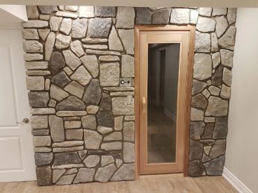 Stone wall with wooden door and glass panel.