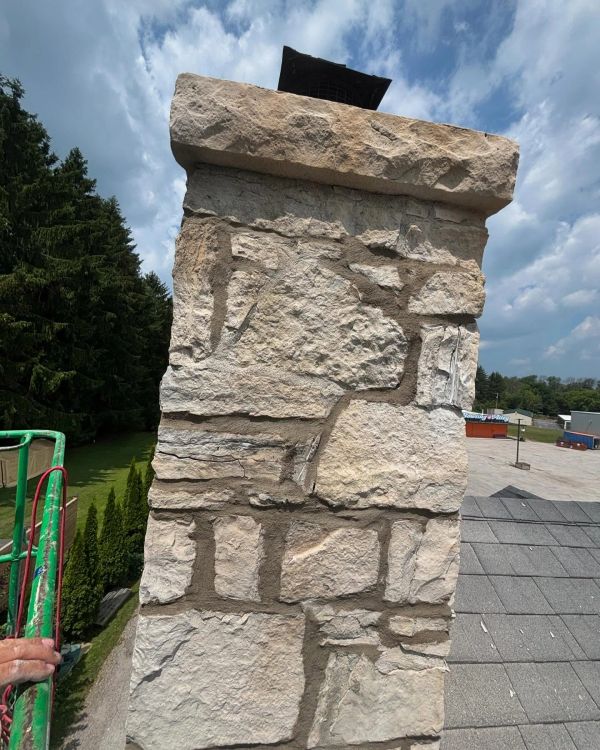 Close-up of a stone chimney on a rooftop.