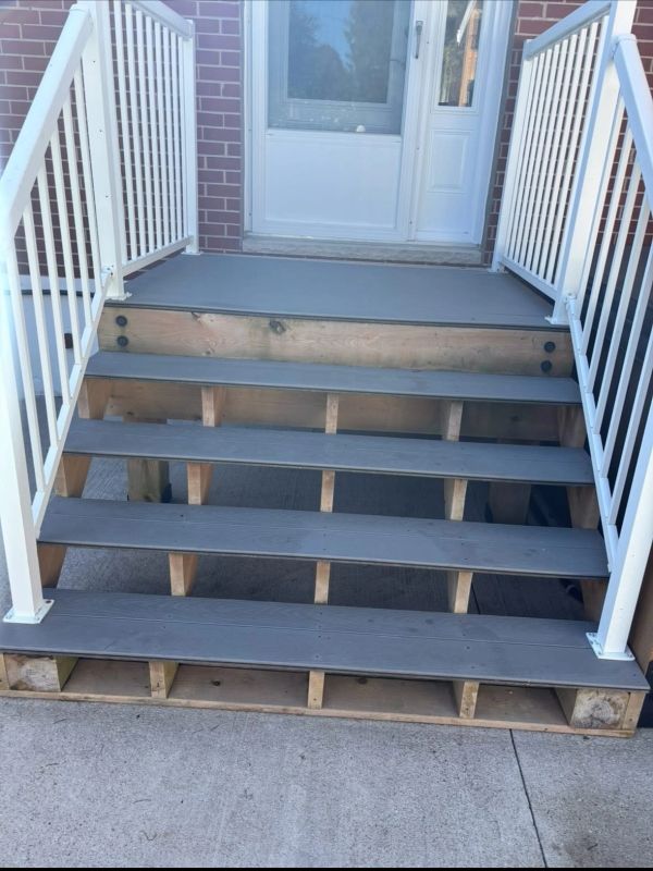 Front view of a gray wooden staircase with white railings.